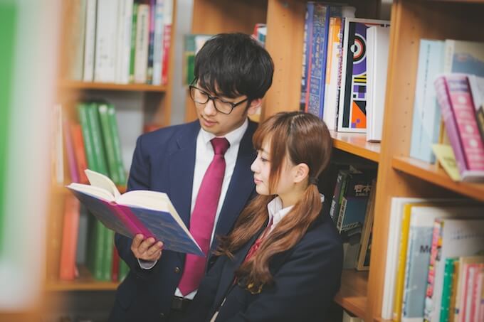 図書室で本を読むカップル